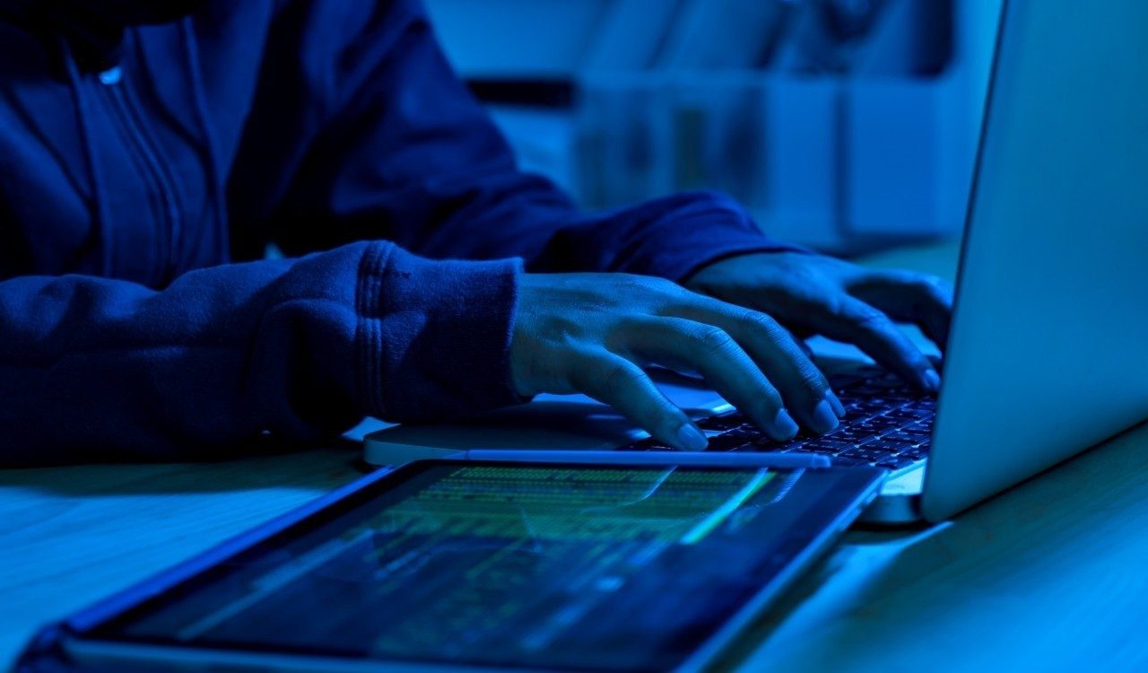 Hands typing on a laptop
